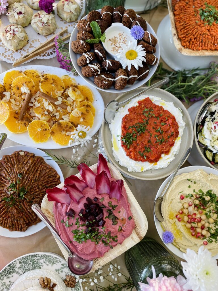 Table dressée pour un apéritif oriental avec mezzés marocains, cigares au fromage, et décorations élégantes
